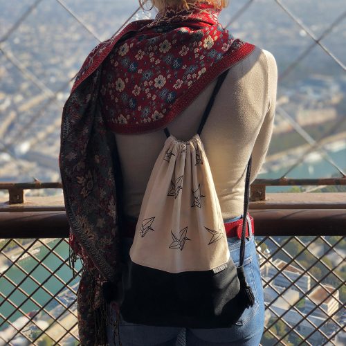 Young girl with drawstring bag on top of eiffel tower
